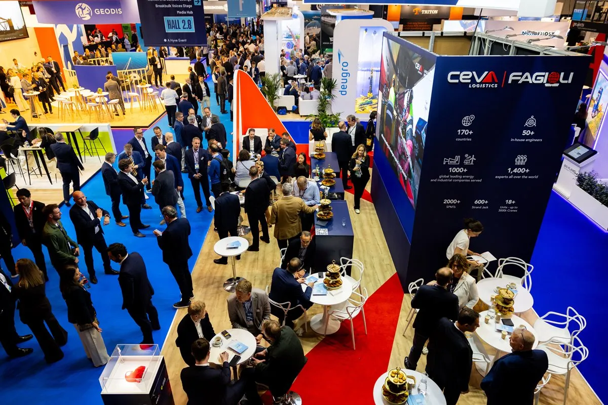 Breakbulk Europe exhibition floor with logistics professionals networking at exhibitor stands.