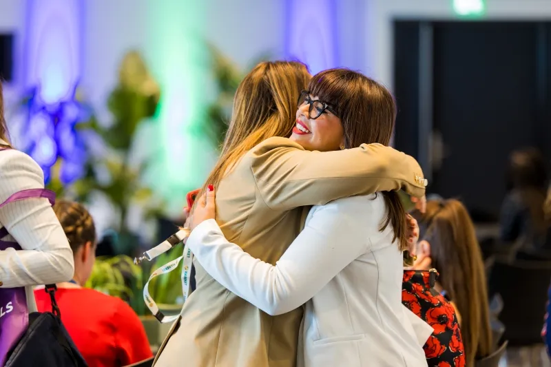 Women embrace at a Women in Breakbulk networking event at Breakbulk Europe.