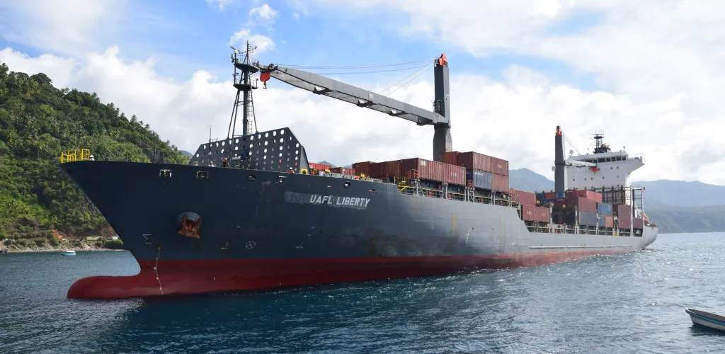 UAFL Liberty cargo ship carrying containers and sailing through coastal waters.