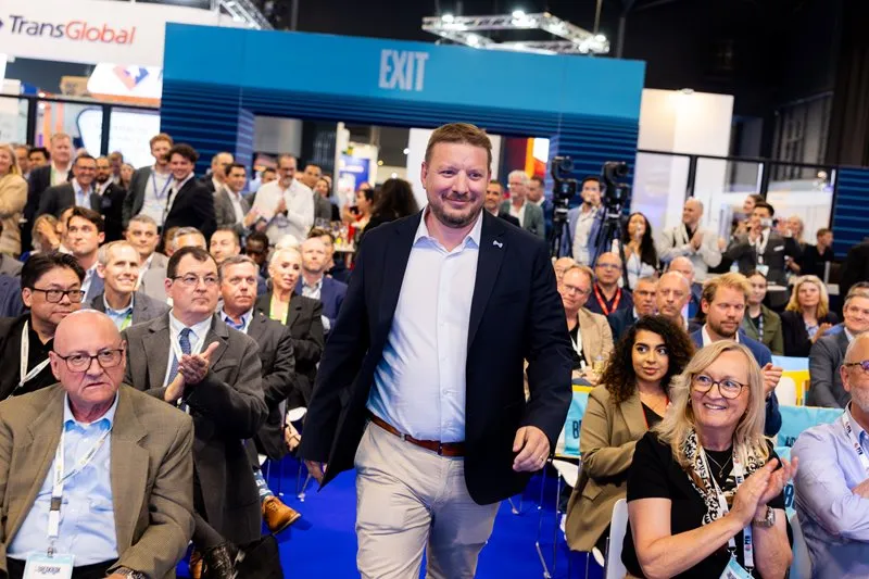 Award recipient walks through an applauding audience at Breakbulk Europe.