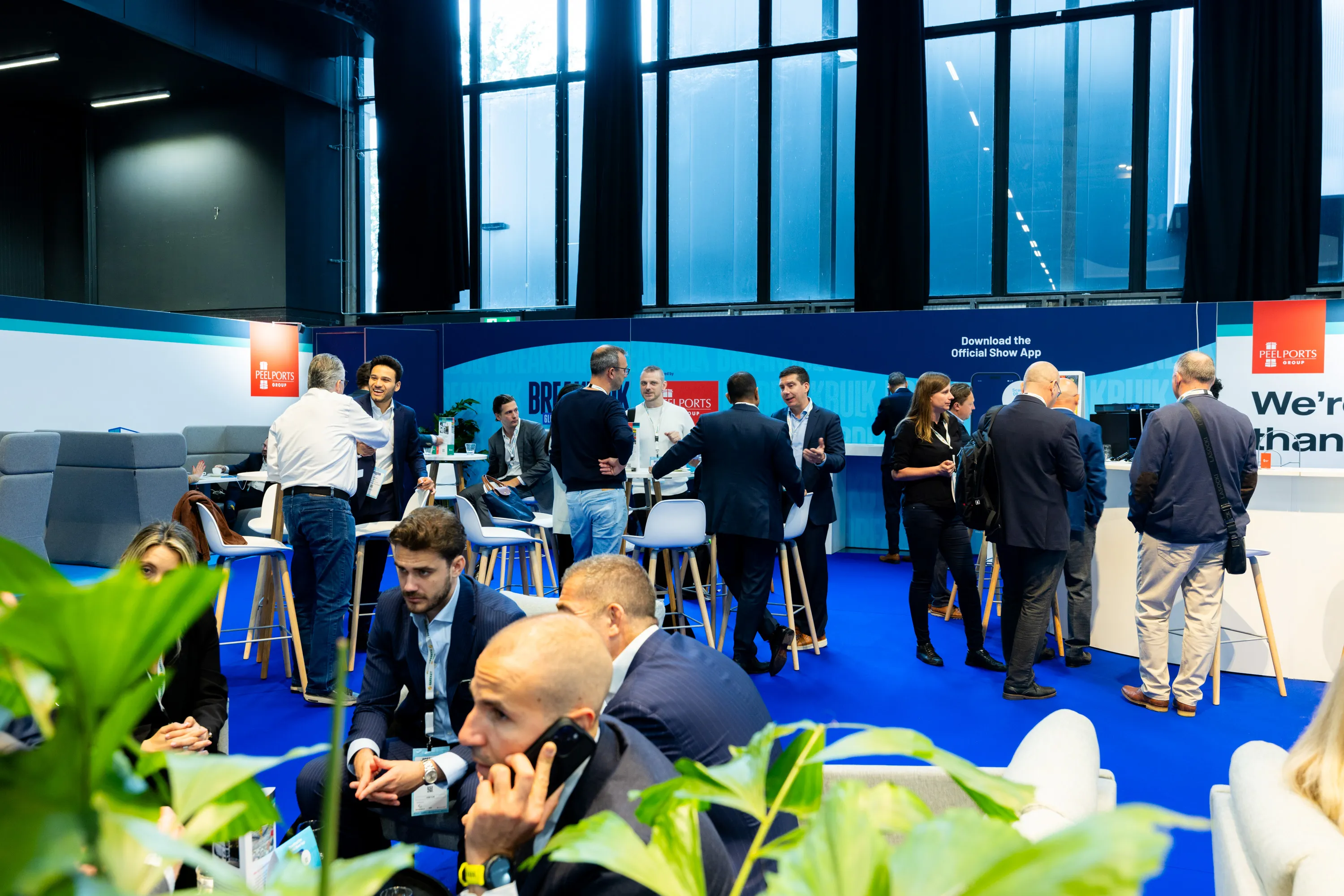 Breakbulk Europe attendees networking and holding business meetings in the event lounge.